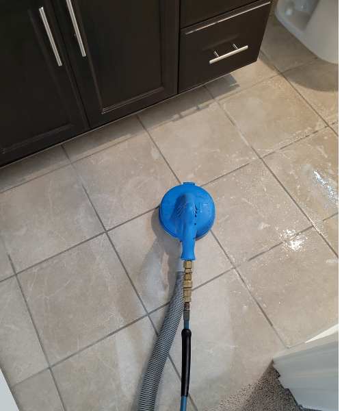 A blue blow dryer sitting on top of a tiled floor