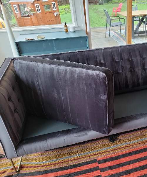 A couch sitting in a living room next to a window