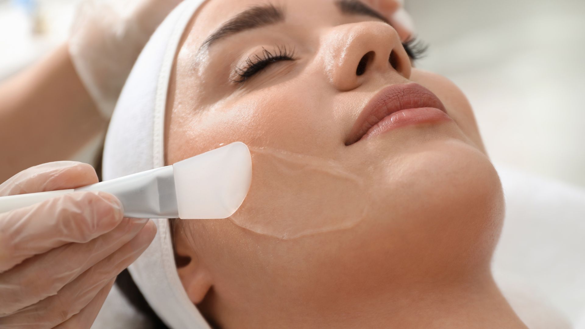 Facial skincare treatment with professional applying mask or cream